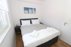 une chambre avec deux lits avec des serviettes blanches dessus dans l'établissement Dolphin view II with a pool by the beach, à Mandre