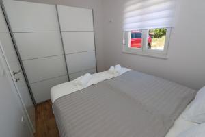 une chambre blanche avec un lit et une fenêtre dans l'établissement Dolphin view II with a pool by the beach, à Mandre