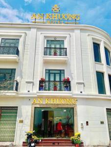 a white building with a sign on top of it at Hotel AN KHƯƠNG in Rach Gia