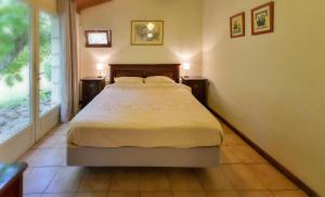 a bedroom with a bed with two night stands and a window at Le Prieuré Le Pavillon in Souillac