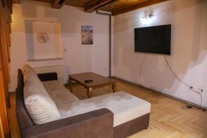 a living room with a couch and a flat screen tv at Careva Cuprija Apartment&Rooms in Sarajevo