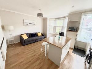 a kitchen and living room with a couch and a table at Entire 2 Bed First Floor Flat in Ealing