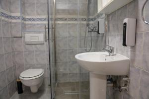 a bathroom with a toilet and a sink and a shower at Careva Cuprija Apartment&Rooms in Sarajevo