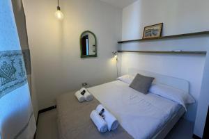 a bedroom with a bed with two towels on it at 4 minuti dalla Spiaggia della Pelosa, Confortevole Appartamento con A-C in Stintino +34 photos