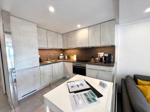 a kitchen with white cabinets and a white table at Exclusive Holiday - Edifico Paraiso Maspalomas in San Fernando