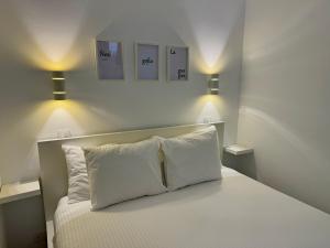 a bedroom with a bed with two pillows and two lights at Exclusive Holiday - Edifico Paraiso Maspalomas in San Fernando +34 photos