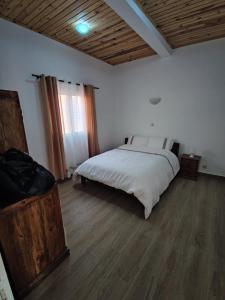 にあるMaison d'hôte Kaz Ain'tsoaのウッドフロアのベッドルーム1室(白いベッド1台付)