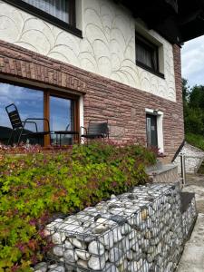 a house with a stone retaining wall and a patio at Studio Donau Radweg-Passau 4 km - Klimaanlage, Parkplatz kostenlos, DONAUErlebnis Card in Hinding