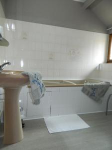 a bathroom with a sink and a bath tub at LOGIS - Auberge Du Colombier in Guînes