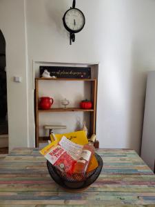 a basket of food on a table with a clock at Charmante Petite Maison Audoise in Trausse +53 photos