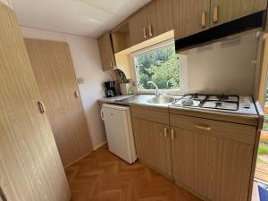 a small kitchen with a sink and a stove at M'Belles Cabanes in Viala-du-Tarn
