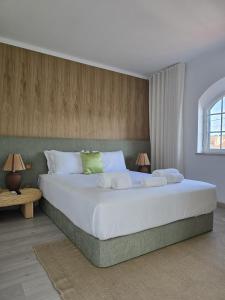 una camera da letto con un grande letto bianco con due lampade di Sesimbra Stylish Villa by Homing a Sesimbra
