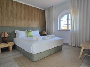 una camera da letto con un grande letto bianco e una finestra di Sesimbra Stylish Villa by Homing a Sesimbra Altre 79 foto