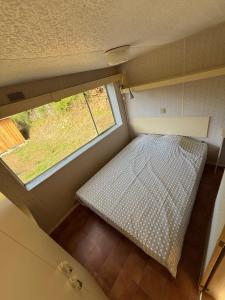 an overhead view of a bed in a small room with a window at M'Belles Cabanes in Viala-du-Tarn +4 photos