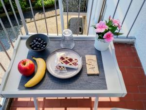 a table with a plate of food and fruit on it at Seriola apartment in Salò