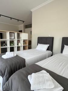 Dos camas en una habitación con paredes blancas. en J&N Living, en Spáta