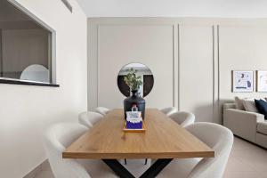 アブダビにあるSilkhaus Spacious 2 BDR Reem Central Park Nearbyのダイニングルームテーブル(椅子、花瓶付)