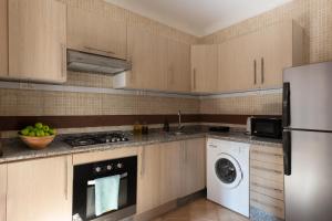 a kitchen with wooden cabinets and a washer and dryer at Marrakech Villa with Private Pool & Family-Friendly in Marrakesh