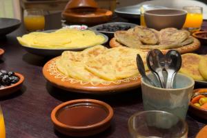 a table topped with plates of food and spoons at Marrakech Villa with Private Pool & Family-Friendly in Marrakesh