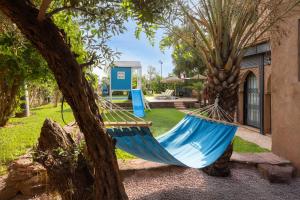 a blue hammock in a yard next to a house at Marrakech Villa with Private Pool & Family-Friendly in Marrakesh