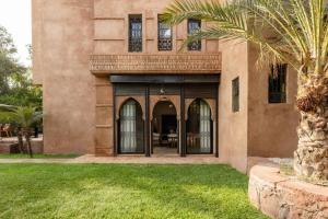 a house with a palm tree in the yard at Marrakech Villa with Private Pool & Family-Friendly in Marrakesh