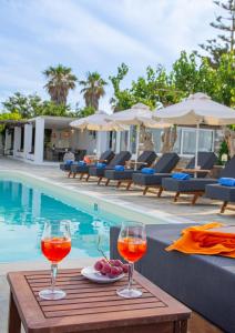 two glasses of wine on a table next to a pool at Fragoulis Village in Parasporos