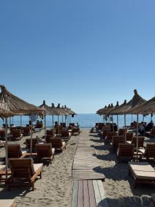 a beach with chairs and umbrellas and the ocean at Beach Apartments Durres in Durrës