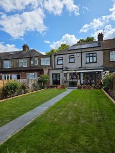 een groot huis met een gazon ervoor bij SAI Residence in Ilford