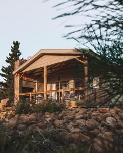 a house on a hill with rocks in front of it at Kingfisher Cabin at Vrolikheid Landgoed in Tulbagh