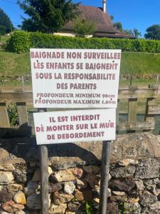 a sign in front of a stone wall at Gîte de la Bastide de Domme in Domme