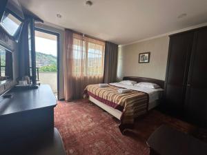 een hotelkamer met een bed en een groot raam bij Hotel Beka Palace in Tbilisi City