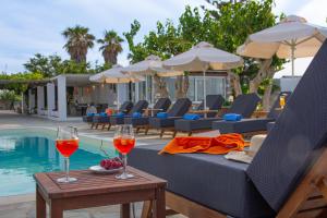 two glasses of wine on a table next to a pool at Fragoulis Village in Parasporos