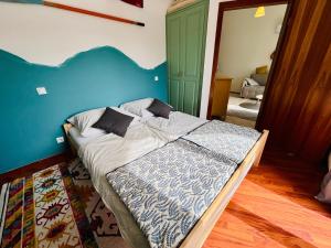una camera da letto con un letto grande con una parete blu di Mimi2 Apartment a Zamárdi Altre 18 foto
