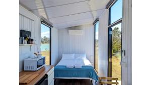 Postel nebo postele na pokoji v ubytování Turtle Island Lakeside Tiny House by Tiny Away