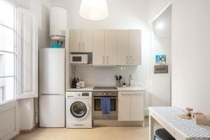 a kitchen with a refrigerator and a washing machine at Cozy Apartment Blanes in Blanes