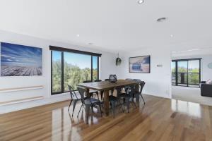 a dining room with a wooden table and chairs at Coastal Escape on Highlander in Torquay