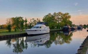 ein Boot mit anderen Booten auf einem Fluss angedockt ist in der Unterkunft L'évasion in Chièvres