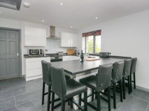 una cucina con un grande tavolo nero e sedie di Fell View Cottage a Kendal