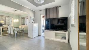 a kitchen with a large television and a table with chairs at Caideros Sunset in Los Caideros