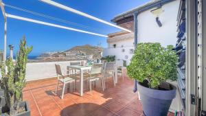 a patio with a table and chairs and a view of the ocean at Caideros Sunset in Los Caideros