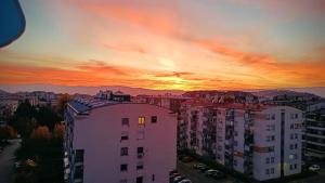 a sunset over a city with tall buildings at Ohrid Demarko Apartment in Ohrid