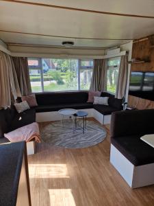 a living room with a couch and a table at Kamperen in Jannum in Janum