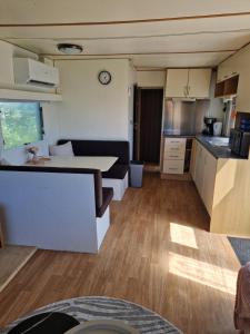 a kitchen and a living room with a table at Kamperen in Jannum in Janum