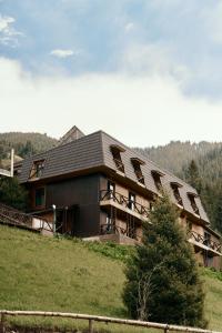 a large building with a roof on a hill at Pana Nomad Kolsay in Kurmenty