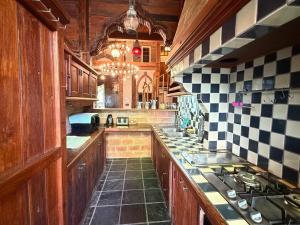 a large kitchen with wooden cabinets and black and white tiles at Villa Adlerhorst in Pai