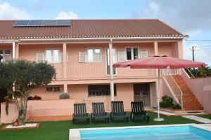 una casa con ombrellone, sedie e piscina di Casa do Avô Gil a Seixo