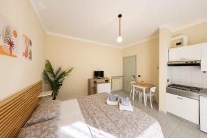 a bedroom with a bed and a small kitchen at Residence Rodi in Alassio