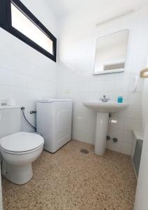 a white bathroom with a toilet and a sink at alquilaencanarias El Medano Spectacular terrace and sea views A in El Médano