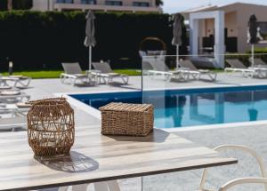 a table with wicker baskets on it next to a pool at White Canvas Boutique Studios in Laganas