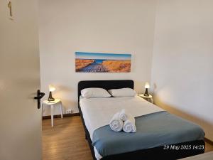 a bedroom with a bed with towels on it at Blife Bandaya private rooms at Faro beach in FAO